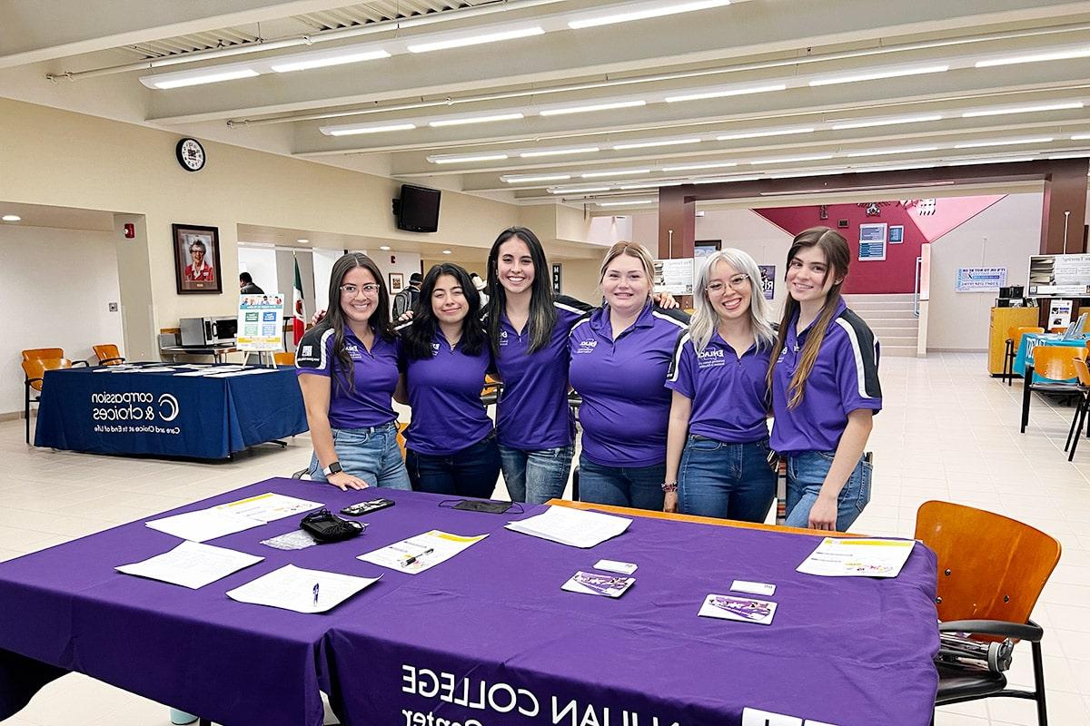 Students from the Herencia Latina Center man a help desk table in Mary's Kitchen